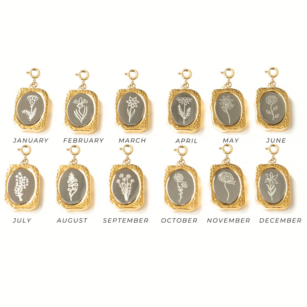 A collection of gold-plated charms, each with a floral design representing a month of the year.